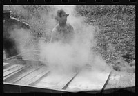 [Untitled photo, possibly related to: Boiling down the sorghum cane sap into syrup. At a mountaineer's home on the highway between Jackson and Campton, Kentucky]. Sourced from the Library of Congress.
