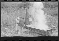 [Untitled photo, possibly related to: In the early fall during "syrupping off" time many of the children stay home from school to eat the freshly boiled down sorghum cane syrup. The cook usually goes to the various farms in the neighborhood and for his work takes a share of the syrup. On the highway between Jackson and Campton, Kentucky]. Sourced from the Library of Congress.