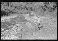 [Untitled photo, possibly related to: Going home from school. In Breathitt County, Kentucky. The school year begins in July and ends in January as most of the children have no shoes and insufficient clothing to walk the long distances over bad roads and up creek beds]. Sourced from the Library of Congress.