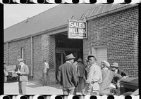 [Untitled photo, possibly related to: Farmers waiting outside of warehouse during tobacco auction sale. Danville, Virginia]. Sourced from the Library of Congress.