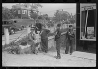 Workers lounging around town and waiting for a lift home at afternoon change of shift of Electric Boat Works, Groton, Connecticut. Sourced from the Library of Congress.