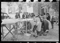 Cleaning up and visiting after outdoor picnic at an all-day ministers and deacons meeting. Near Yanceyville, Caswell County, North Carolina. Sourced from the Library of Congress.