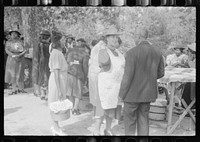 Cleaning up and visiting after outdoor picnic at an all-day ministers and deacons meeting. Near Yanceyville, Caswell County, North Carolina. Sourced from the Library of Congress.