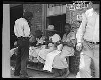 Lunchtime for these Georgia peach pickers. They earn seventy-five cents a day in the orchards. Muscella, Georgia. Sourced from the Library of Congress.
