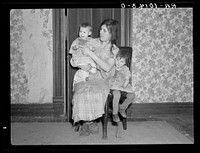 Mrs. Alfred Atkinson with baby and young child in farm home near Shannon City, Iowa. They rent eighty acres from an estate by Russell Lee