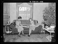 Children of H.H. Tripp wrapping presents for Christmas. Near Dickens, Iowa. Tripp operates his mother's farm by Russell Lee