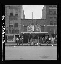Idle men attend the morning movies. There are three such movies in one block. Oklahoma City, Oklahoma. Sourced from the Library of Congress.