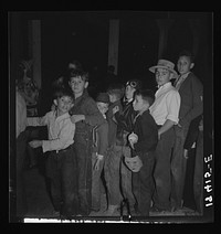 The children crowd and push to reach refreshments at Halloween party. Shafter migrant Camp, California  by Dorothea Lange