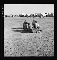 Marble time in Farm Security Administration (FSA) migratory labor camp (emergency). Plenty of space to play and plenty of companions for the children during pea harvest. Near Calipatria, Imperial Valley. California. Sourced from the Library of Congress.