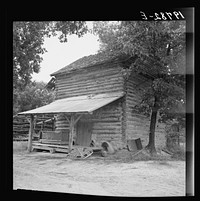 [Untitled photo, possibly related to: Tobacco barn with tobacco sled and vehicle used for conveying tobacco sleds. Person County, North Carolina]. Sourced from the Library of Congress.