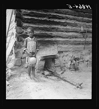 [Untitled photo, possibly related to: Grandchildren of tobacco sharecropper down at barns. Note construction of tobacco sleds which have just been repaired by Zollie Lyons. Beyond them the screened platform in which that member of the family sleeps who tends the fire during the night. Wake County, North Carolina]. Sourced from the Library of Congress.