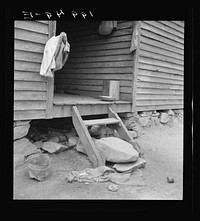 [Untitled photo, possibly related to: Porch leading to kitchen of sharecropper cabin. They have been putting up strawberries. The sack which hangs on the side wall was used as a strainer Person County, North Carolina]. Sourced from the Library of Congress.