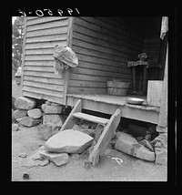 Porch leading to kitchen of sharecropper cabin. They have been putting up strawberries. The sack which hangs on the side wall was used as a strainer  Person County, North Carolina. Sourced from the Library of Congress.