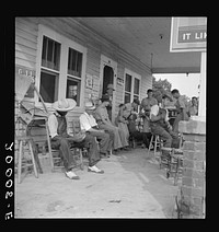 Rural filling station becomes community center and general grounds for loafing. The men in baseball suits are on a local team which will play a game nearby. The team is called the Cedargrove Team. Fourth of July, Near Chapel Hill, North Carolina. Sourced from the Library of Congress.