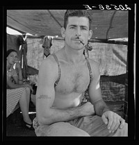 Untitled photo, possibly related to: Unemployed lumber worker goes with his wife to the bean harvest. Note social security number tattooed on his arm. Oregon.. Sourced from the Library of Congress.