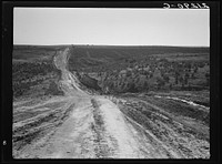 Landscape on top of bench, showing new lands, and farms beyond. Road was built by the CCC (Civilian Conservation Corps). Dead Ox Flat, Malheur County, Oregon. General caption number 67-1. Sourced from the Library of Congress.