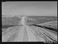 View of newly reclaimed bench land. Emmett Smith (farm in background),  "took his place out of the bush 3 years ago." Dead Ox Flat, Malheur County, Oregon. General caption 67. Sourced from the Library of Congress.