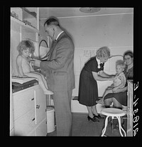 Doctor examining children in trailer clinic. FSA (Farm Security Administration) mobile camp, Klamath County, Oregon. See general caption 62. Sourced from the Library of Congress.