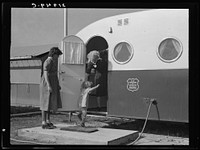 Young mother brings her child to the trailer clinic on the day when the doctor will be in camp to examine some of the children. Merrill, Klamath county, Oregon. FSA (Farm Security Administration) camp. Sourced from the Library of Congress.