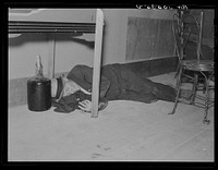 Lumberjack under the table in a saloon. Craigville, Minnesota by Russell Lee