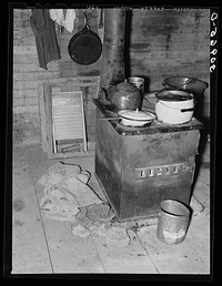 Kitchen stove and bag full of cow dung used as fuel. Sheridan County, Montana by Russell Lee