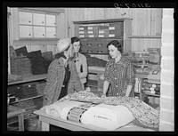 Southeast Missouri Farms. Customers examining yard goods in cooperative store. La Forge project, Missouri by Russell Lee