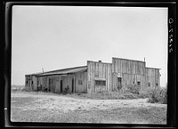 Old warehouse, once the station for early Mississippi River steamboat travel, Caruthersville, Missouri, now inhabited by squatters by Russell Lee