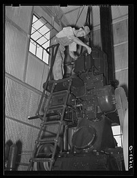 Working on diesel engine in power plant of cotton gin. Lake Dick Project, Arkansas by Russell Lee