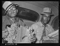 African American musicians playing accordion and washboard in automobile. Near New Iberia, Louisiana Unlink by Russell Lee