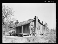  cabin, showing grass and mud chimney and broom made of corn husks for sweeping yard. Taylorsville, Mississippi by Russell Lee