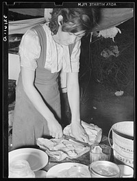 Married daughter of  migrant worker cutting salt meat for dinner. Near Harlingen, Texas (see 32108-D) by Russell Lee
