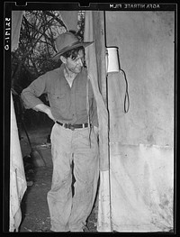 White migrant father standing in doorway of tent home near Harlingen, Texas. See 32108-D by Russell Lee