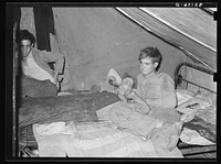 White migrant worker lying on bed in tent home near Mercedes, Texas. See 32108-D by Russell Lee