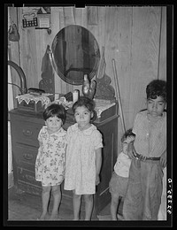 [Untitled photo, possibly related to: Children of Mexican labor contractor in their home. Robstown, Texas. Note the shrine above the children. These shrines, many quite primitive, are found in practically all Mexican homes] by Russell Lee