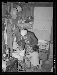Mexican mother in crowded home. Notice the covered windows. Crystal City, Texas by Russell Lee