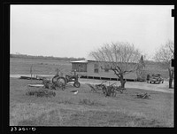 [Untitled photo, possibly related to: Farmhouse of small farmer near Santa Rosa, Texas. Tractor and rusting farm implements are in the yard, showing the changes in farming methods and also demonstrating that even the small farmers are using the new tractors and other mechanized equipment] by Russell Lee