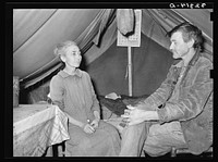 White migrant and his wife in camp near Sebastian, Texas. Both are west Texans who have come to the valley for the winter vegetable harvest by Russell Lee