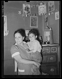 Mexican mother and child in front of shrine in corner of room. San Antonio, Texas by Russell Lee