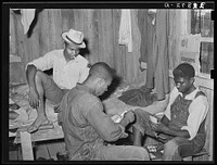 Game of "coon-can" played by group of es in bunkhouse of strawberry pickers near Hammond, Louisiana by Russell Lee