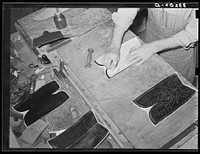 Transferring pattern for stitching on the uppers of the boots. Bootmaking shop, Alpine, Texas by Russell Lee