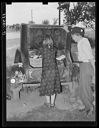 Migrants loading rear deck of automobile while camped near Prague, Oklahoma. Lincoln County, Oklahoma by Russell Lee