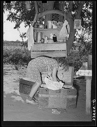 Migrant child packing a trunk at camp home near Muskogee, Oklahoma. Muskogee County by Russell Lee