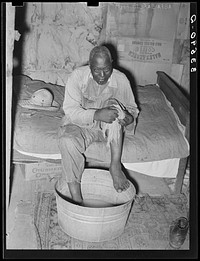 agricultural day laborer washing his feet near Vian, Oklahoma. Sequoyah County by Russell Lee