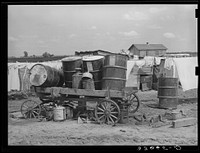 Scene on a tractor farm. Trailer loaded with oil drums. In Arkansas River bottoms near Vian, Oklahoma. Former tenant farmer is now day laborer by Russell Lee