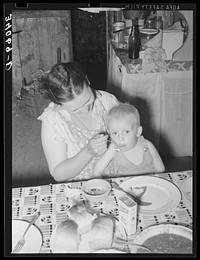 Wife of unemployed oil worker feeding her baby. Seminole, Oklahoma by Russell Lee
