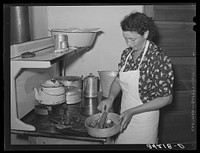 Spanish-American woman removing peppers from stove. Taos, New Mexico by Russell Lee
