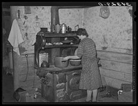 Preparing dinner in farm home of FSA (Farm Security Administration) client near Bradford, Vermont. Orange County by Russell Lee