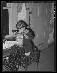 Daughter of FSA (Farm Security Administration) client looking into candy jar. Farm near Bradford, Vermont by Russell Lee