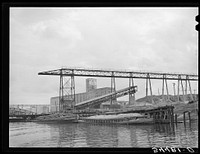 Oyster shell barges at unloading dock of cement plant. Port of Houston, Texas by Russell Lee