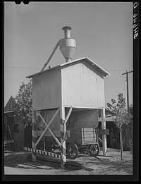 Wagon on scales at feed mill. Taylor, Texas. Ground feed is poured directly into the wagon from the hopper above by Russell Lee